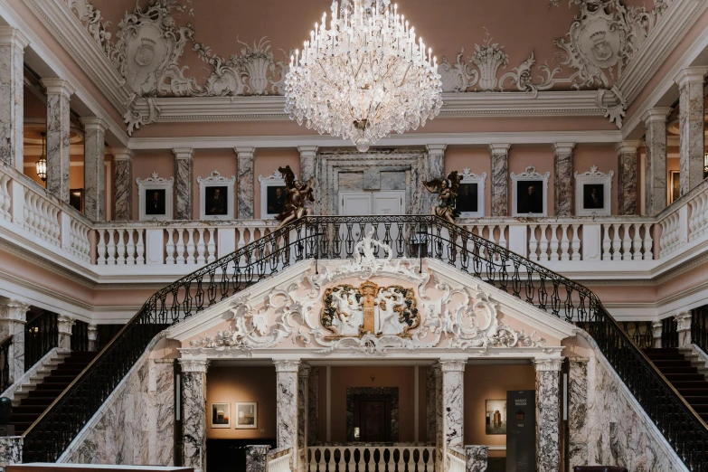 a grand staircase with chandelier over it