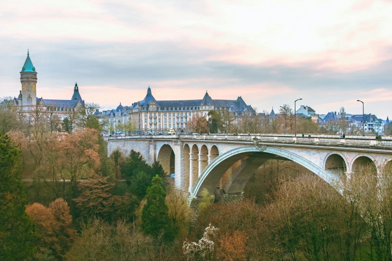 an old bridge is in front of a scenic city