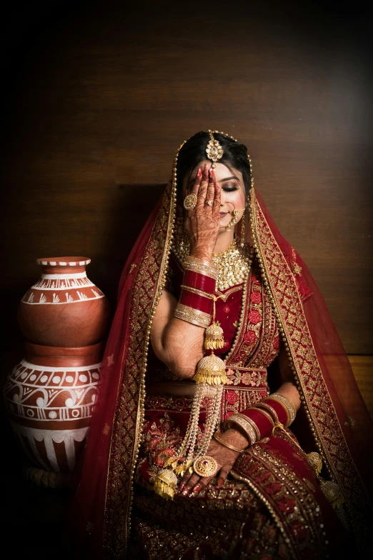 indian bride sitting in front of her urn on her wedding day