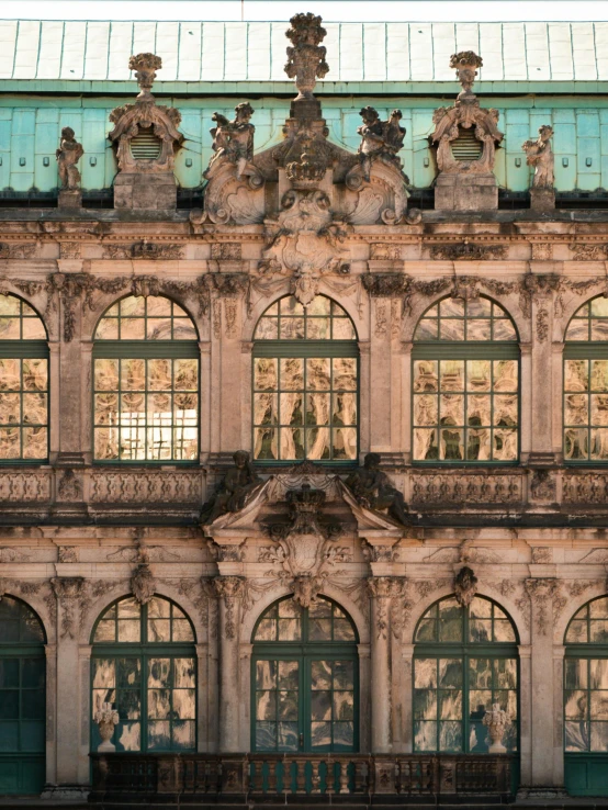 many windows and statues all in front of a building