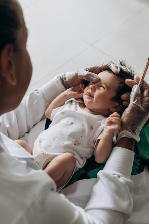 a man holding a baby with her hand over her head