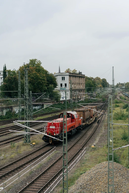 a train on the railroad tracks with buildings in the background