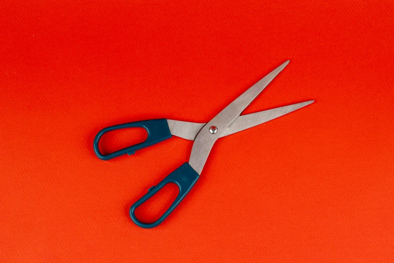 a pair of scissors resting on a red background