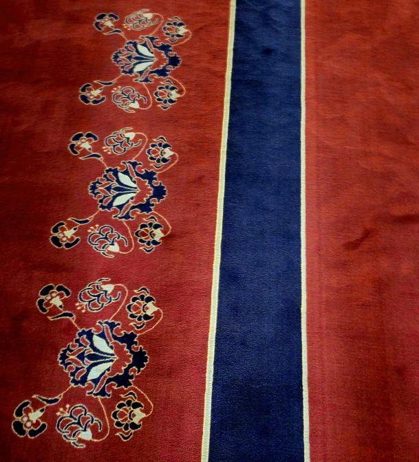 a red rug with a blue stripe is laid on a white table