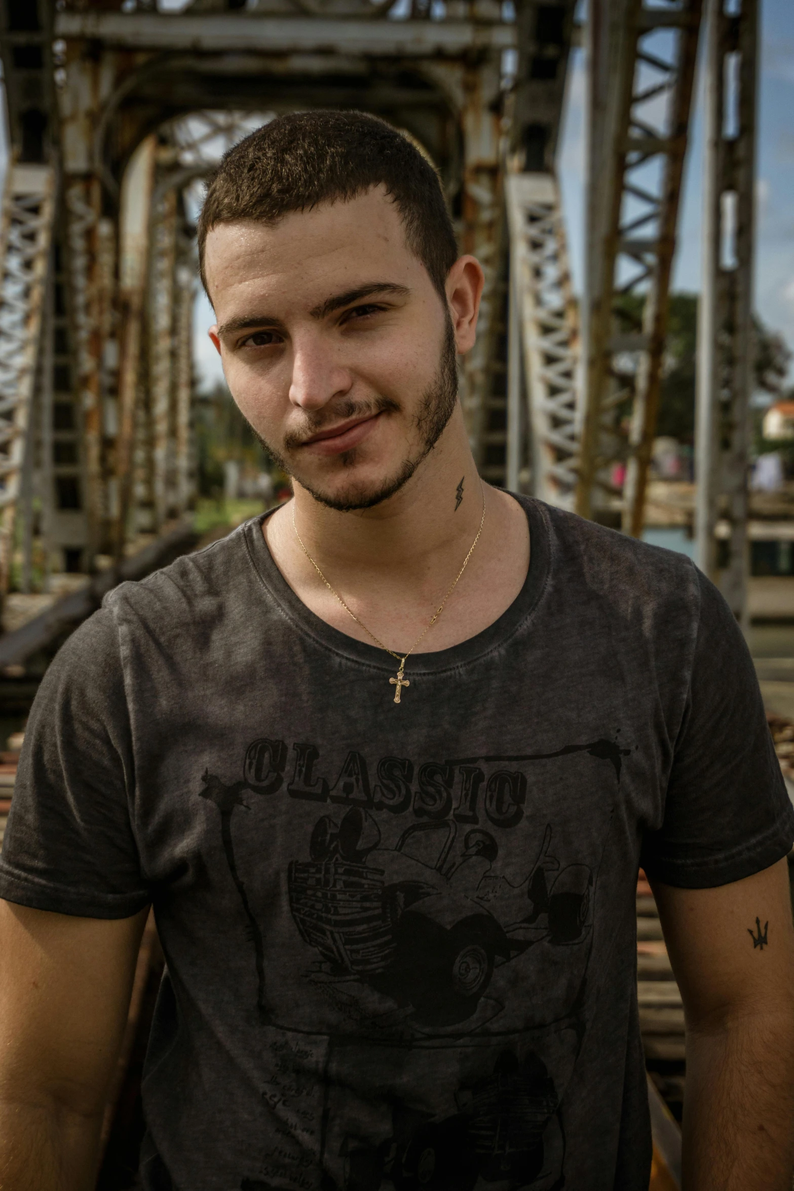 a man standing on train tracks in front of a bridge