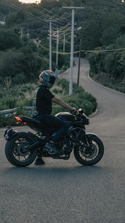 a person is sitting on a motorcycle down the street