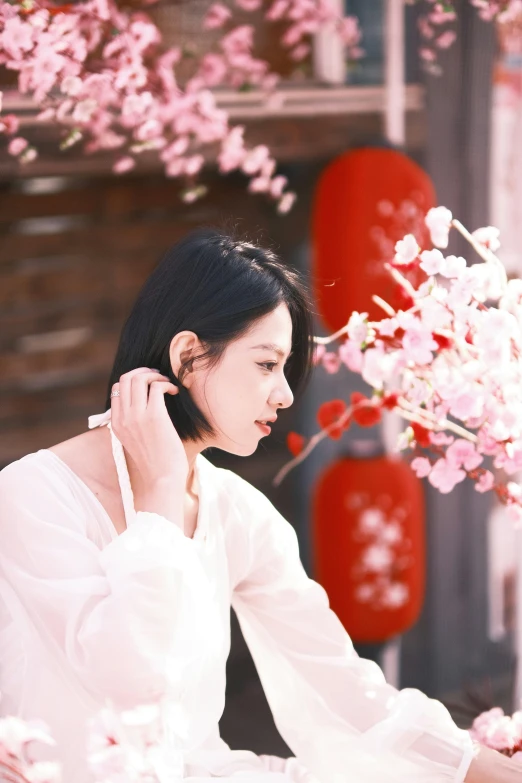 a woman sitting on top of a couch next to flowers