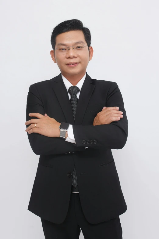 a man in a black suit with his arms folded