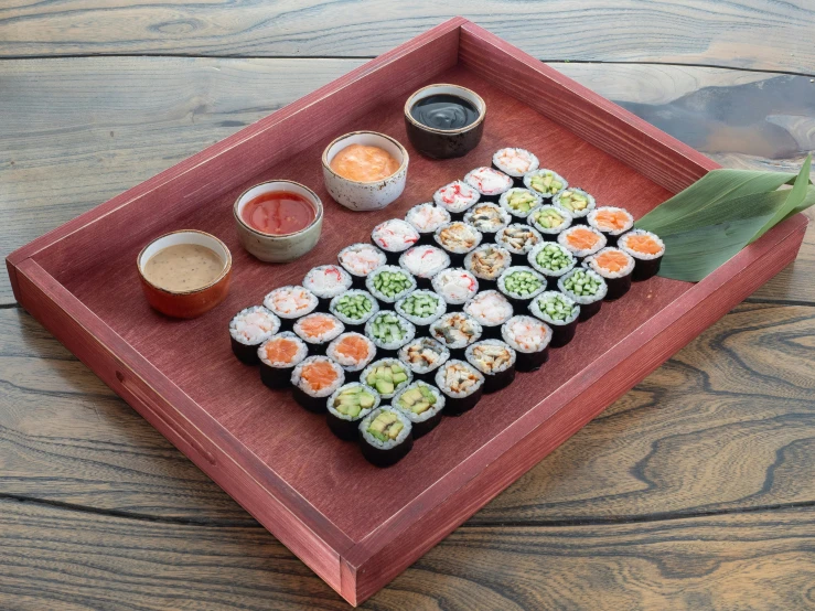 a sushi platter with two sections of sushi and some dipping sauces