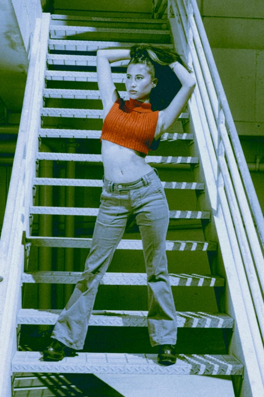 a young woman poses at the bottom of an escalator