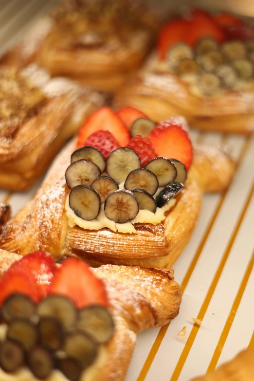 many different pastries and fruit are in a dish