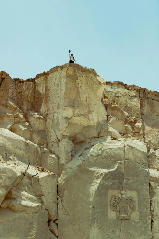 two birds standing on the top of some rock formations