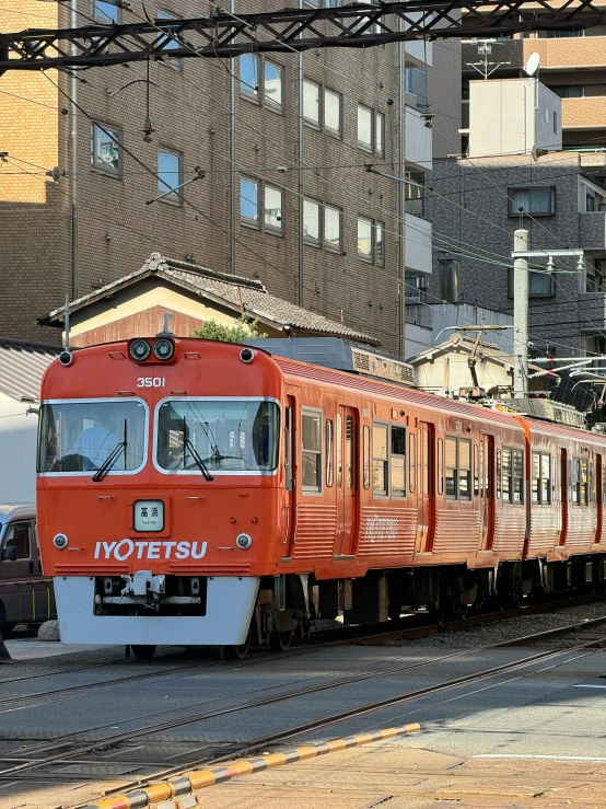 a red train is traveling down the railroad tracks