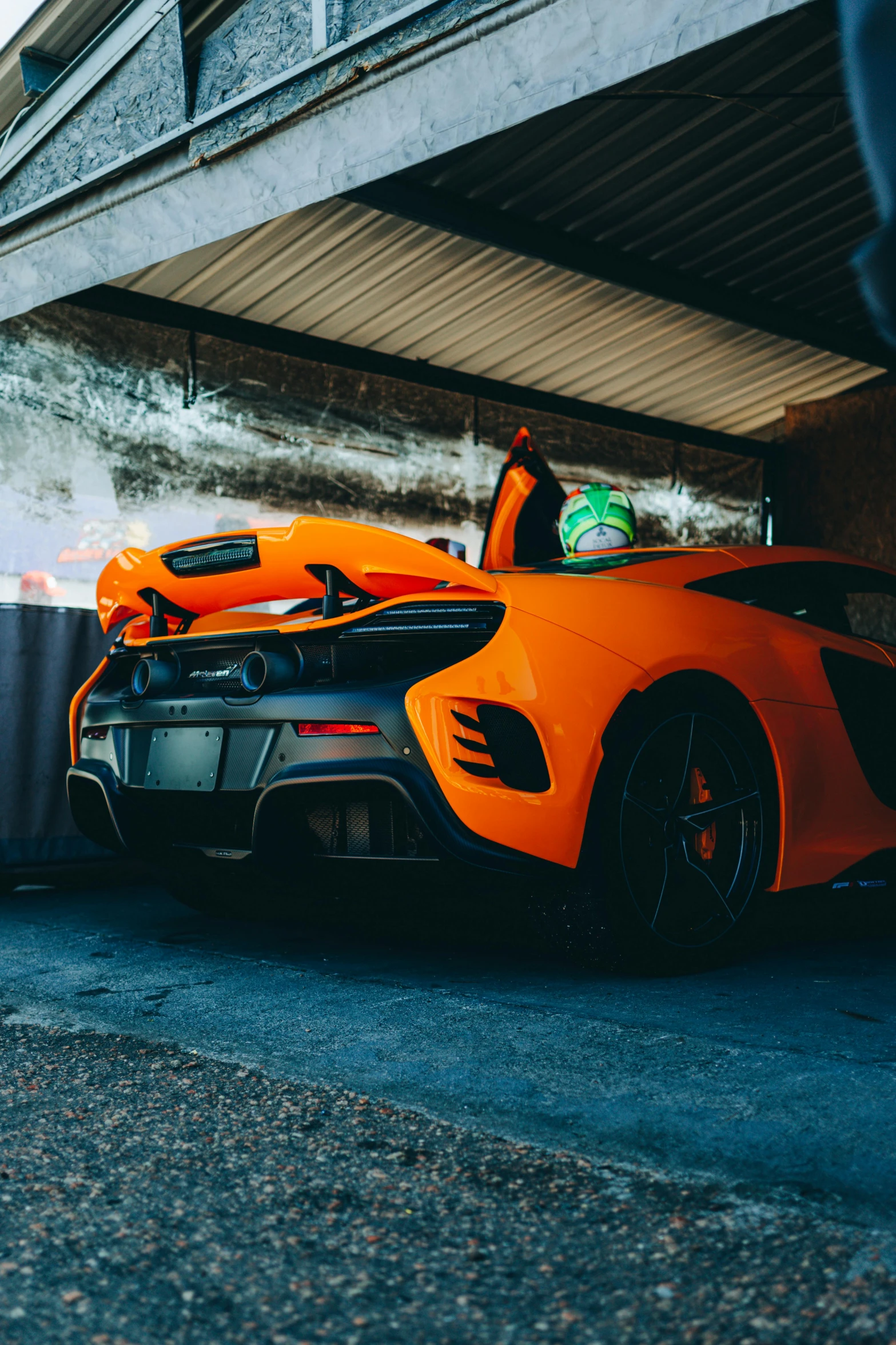 the orange sports car is parked on the side of the road