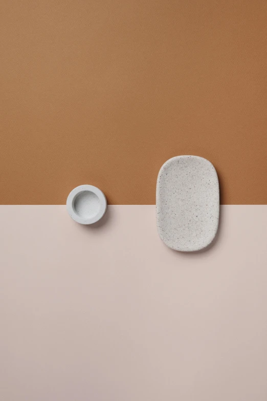 three bowls, one white, one gray, on a beige and brown background