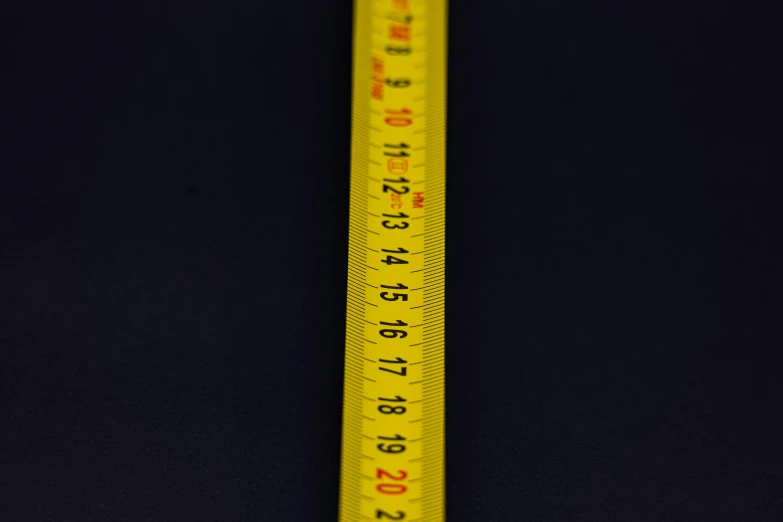 there is a measuring ruler next to a black wall