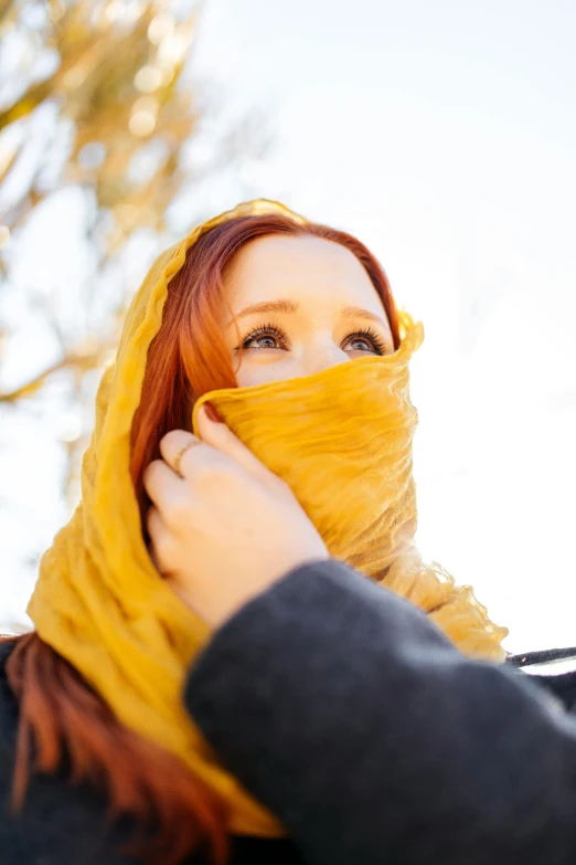 a woman with a yellow head covering around her face