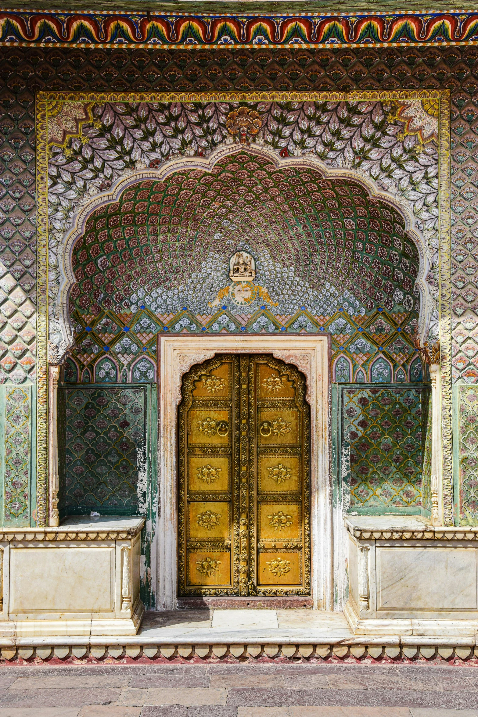golden door in ornate, green building with pillars
