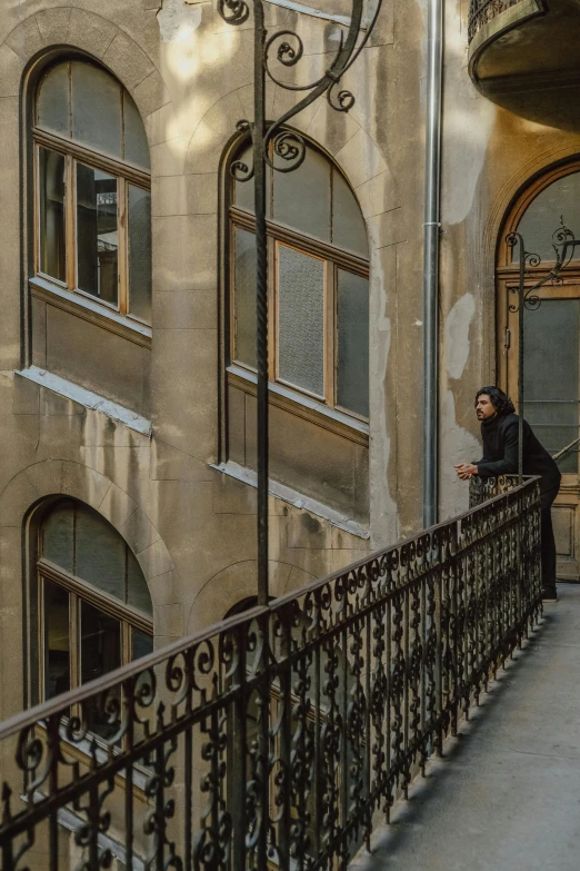 a person standing on the steps of a building with ornate windows