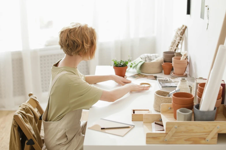 a little boy in a tan shirt is making plants