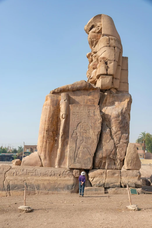 the large sphinx statue stands next to a man in a desert