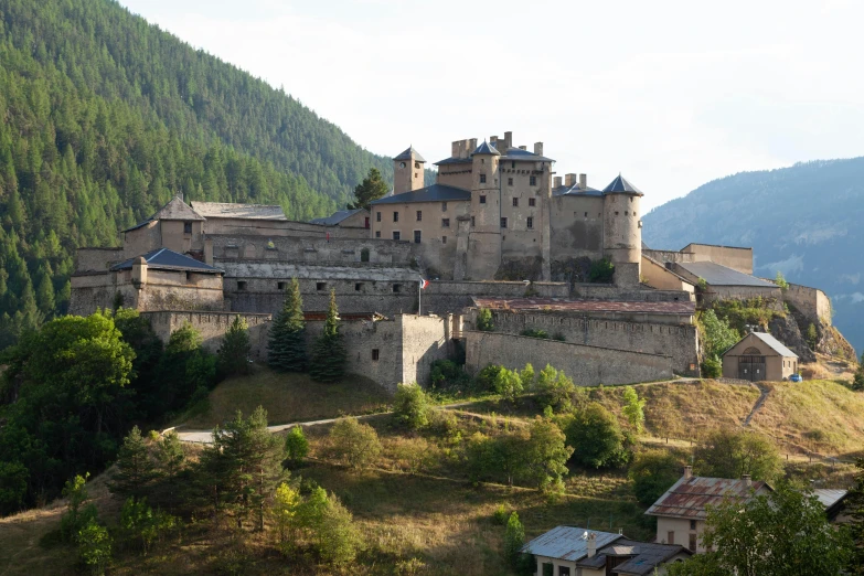 a castle perched on top of a mountain surrounded by forest