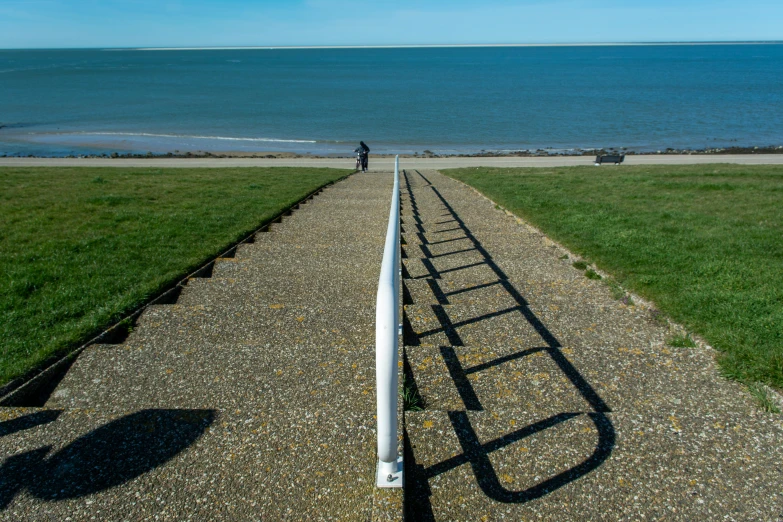 someone walking on a long path to the beach