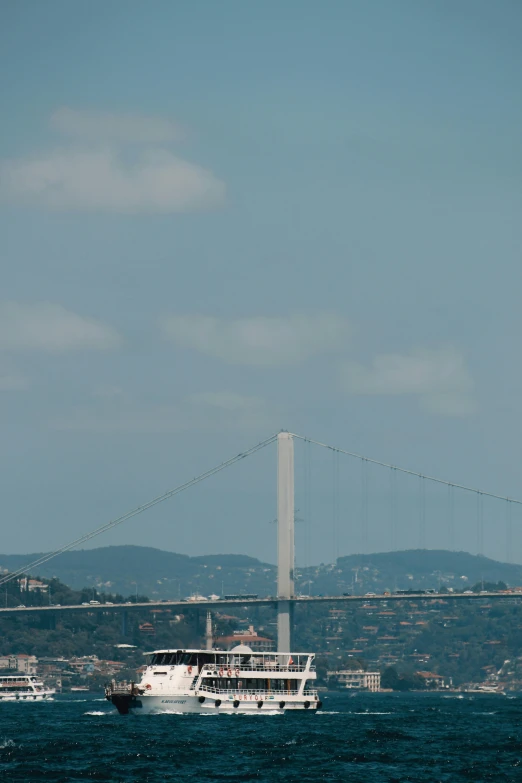 a boat that is sailing in the water near a large bridge