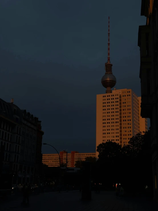 an empty city square next to buildings with a large building in the middle at night