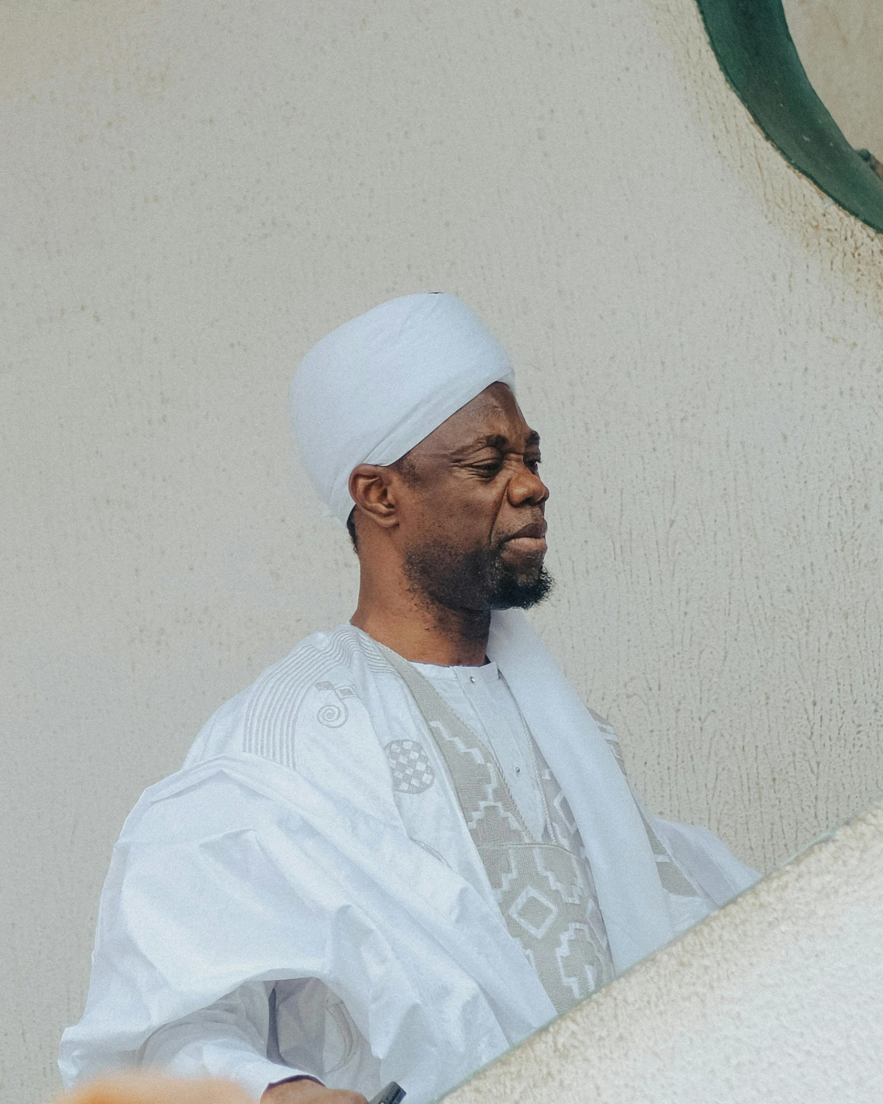 a man wearing a white hat is staring ahead