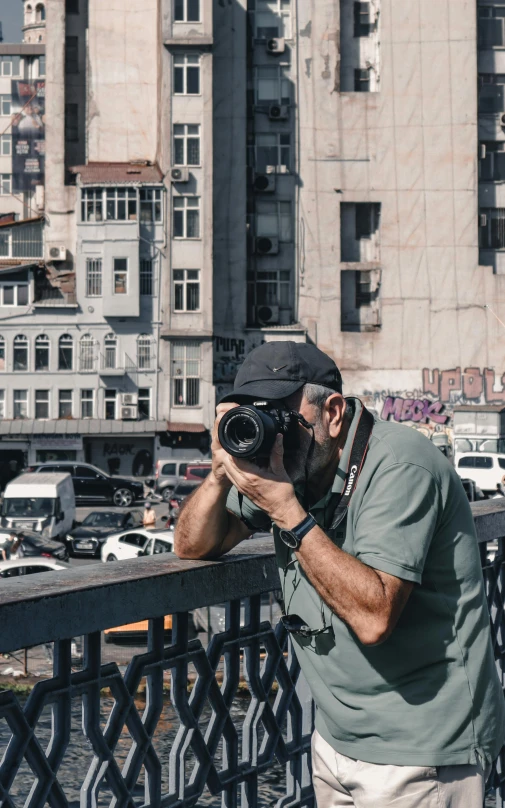 a man standing on the side of a bridge taking a picture