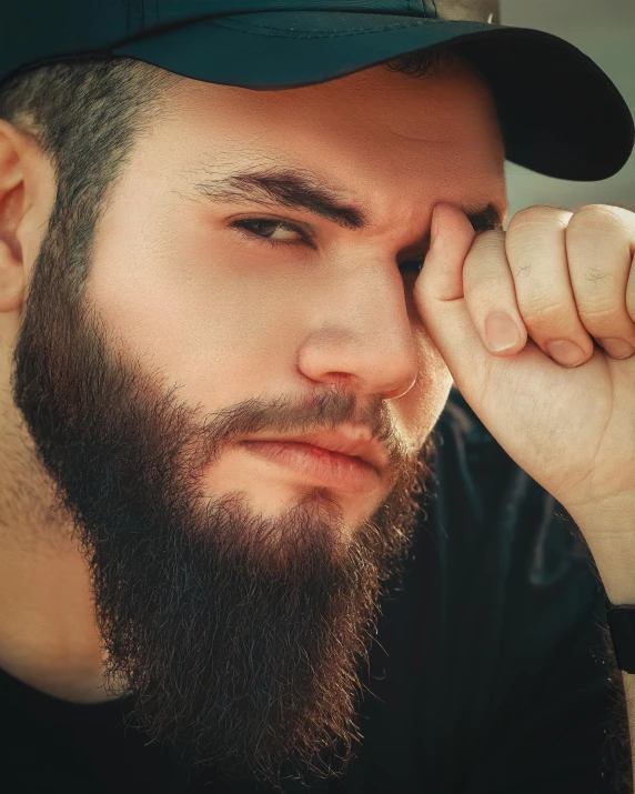 a man with a beard and long hair wearing a cap