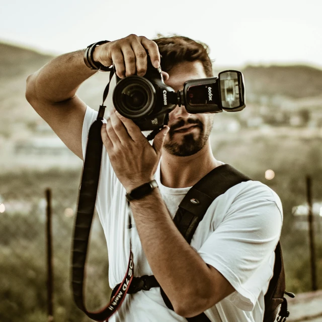 a man holding up his camera in front of his eyes