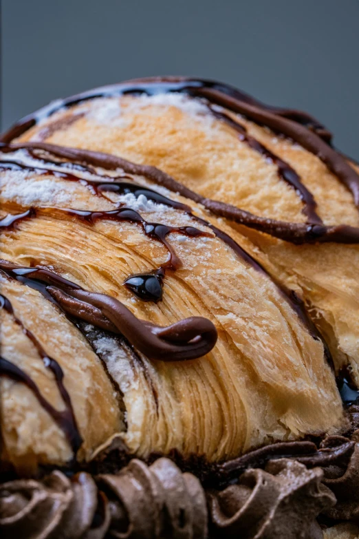 three croissants with chocolate syrup drizzled on top