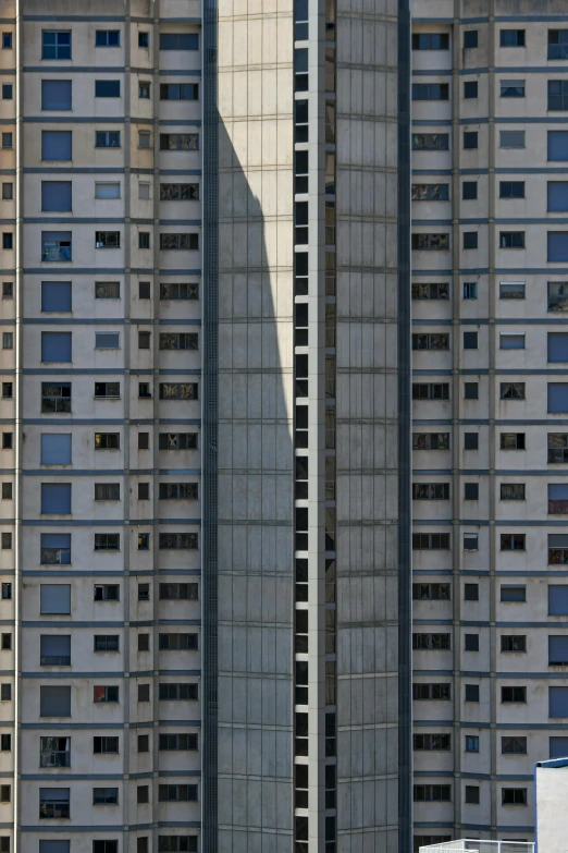 two tall buildings with windows and an airplane flying below