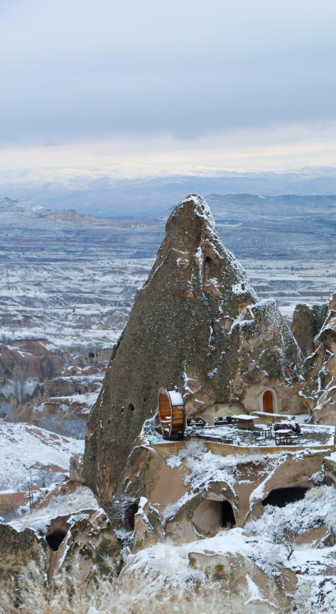 small shelters with snow covered roof overlooking the valley