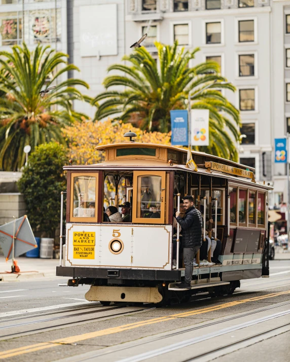 a man is sitting on a trolly while others are standing