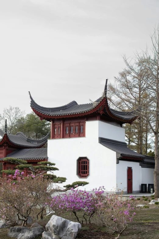 a white house with flowers and rocks around it