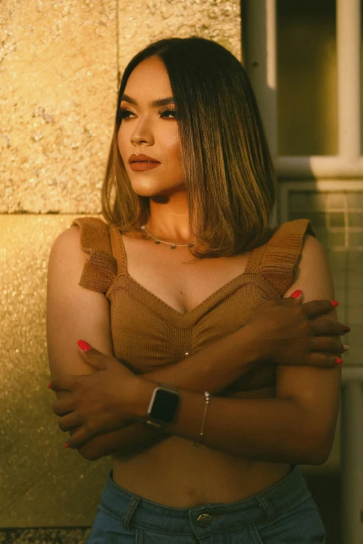 woman with arms crossed standing in front of wall