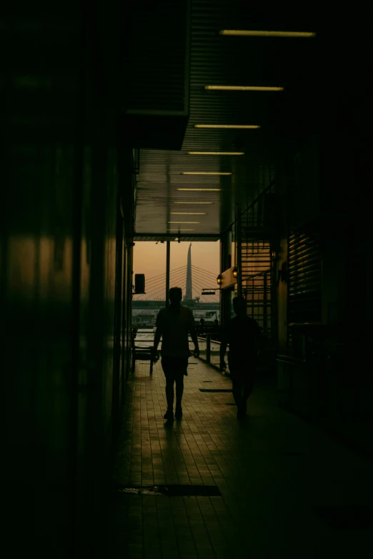 silhouette of people walking in a hallway towards an airport