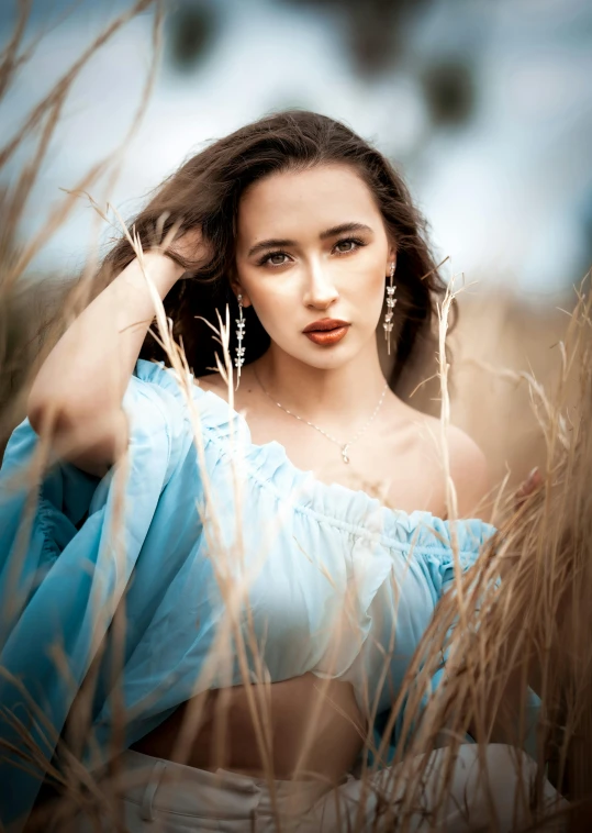 a woman in a blue dress in tall grass