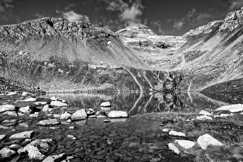 a mountain range reflected in the still water of a lake