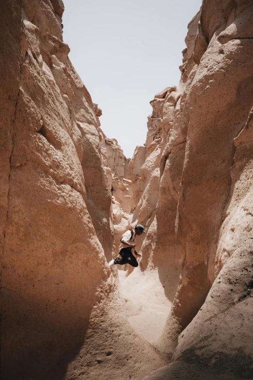 a man walking up some very tall rocks