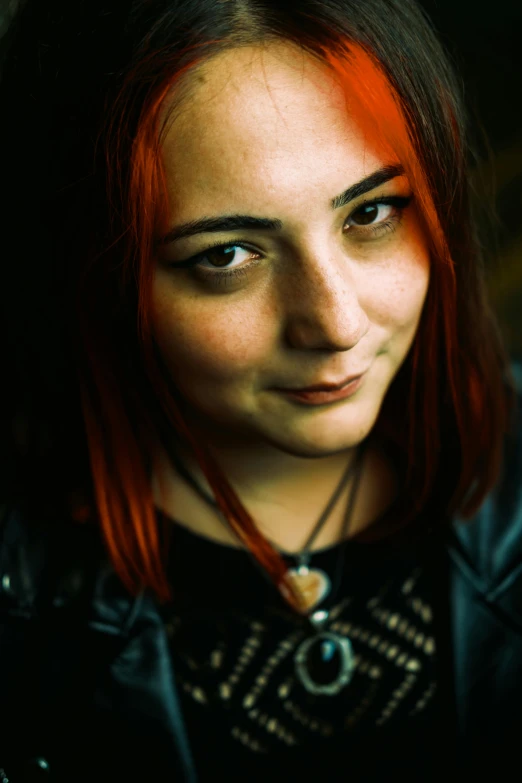 a young woman with red hair smiling with an open face