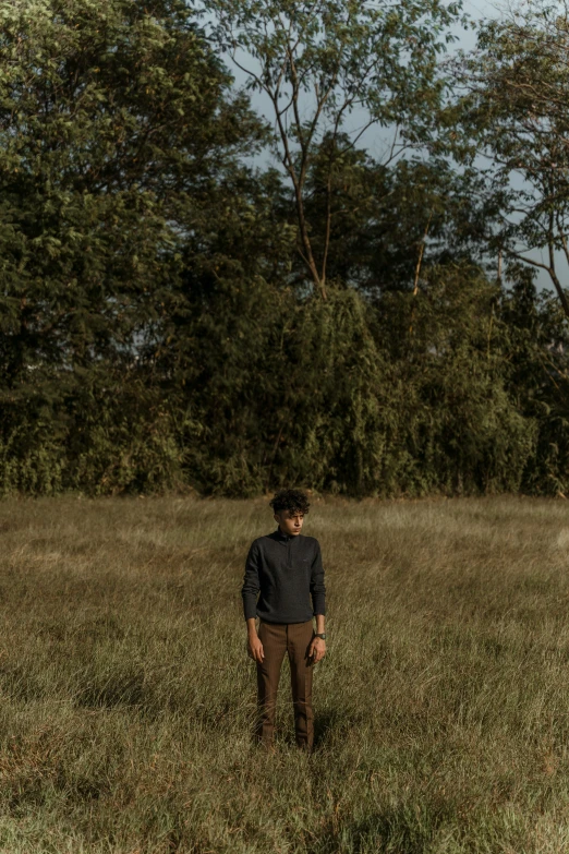 a man that is standing in some grass