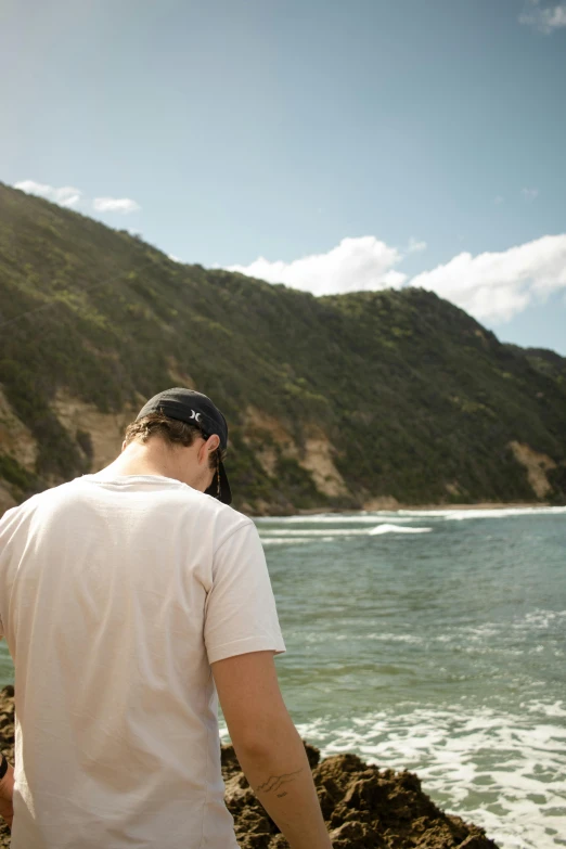 man overlooking a body of water with mountains in the background