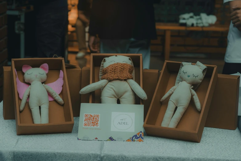 some stuffed cats in boxes on a table