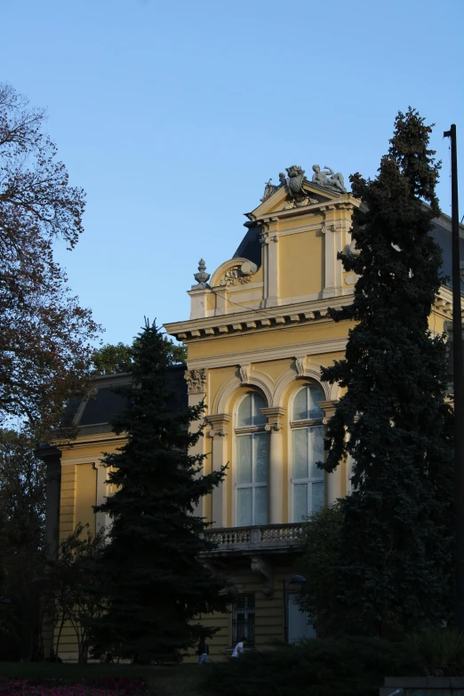 a large house next to trees on a sunny day