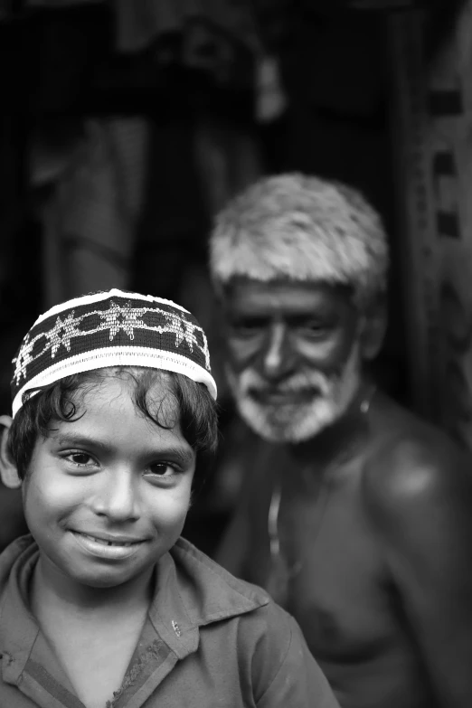 a black and white po shows a boy standing next to an older man