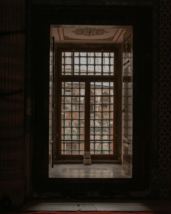 an open window with small dark panels and decorative wooden frame